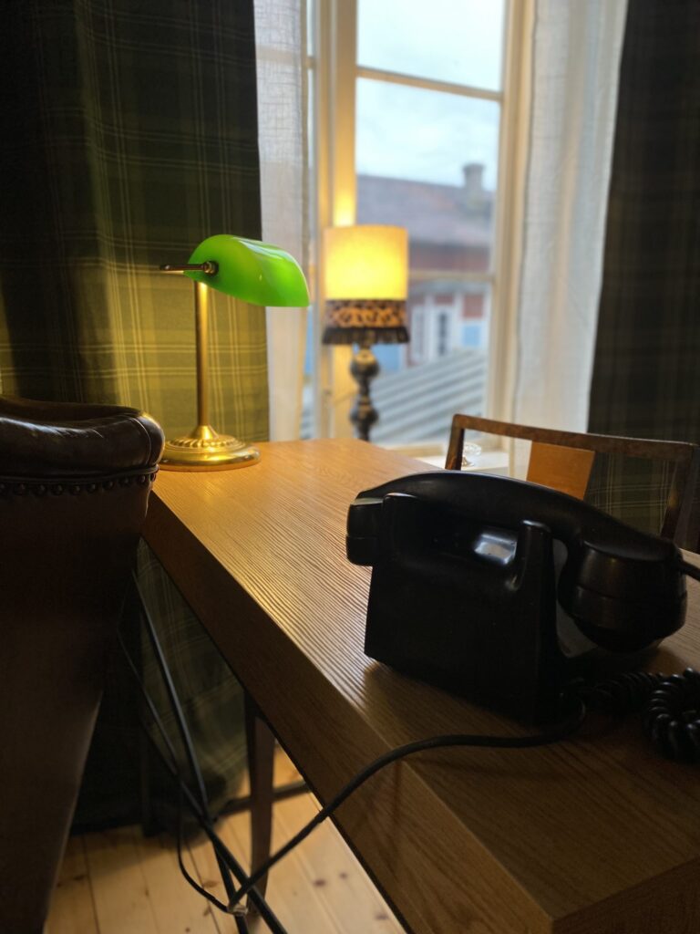 En gammal svart telefon på ett skrivbord